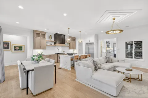 a living room with furniture a chandelier and a dining table
