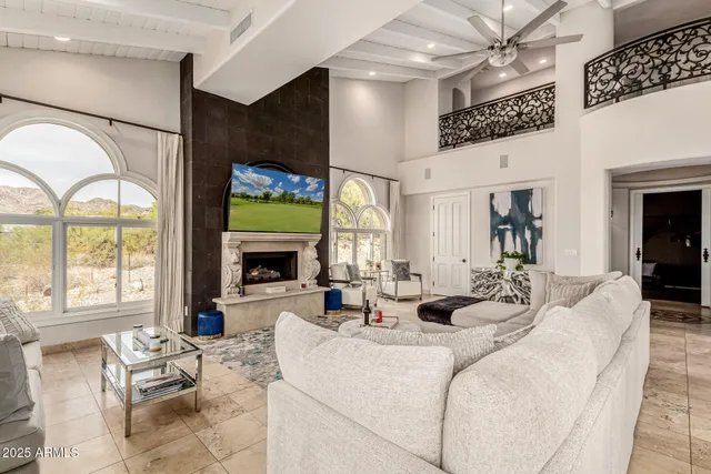 a living room with fireplace furniture and a large window