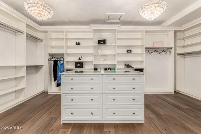 a bedroom with a large bed and a chandelier