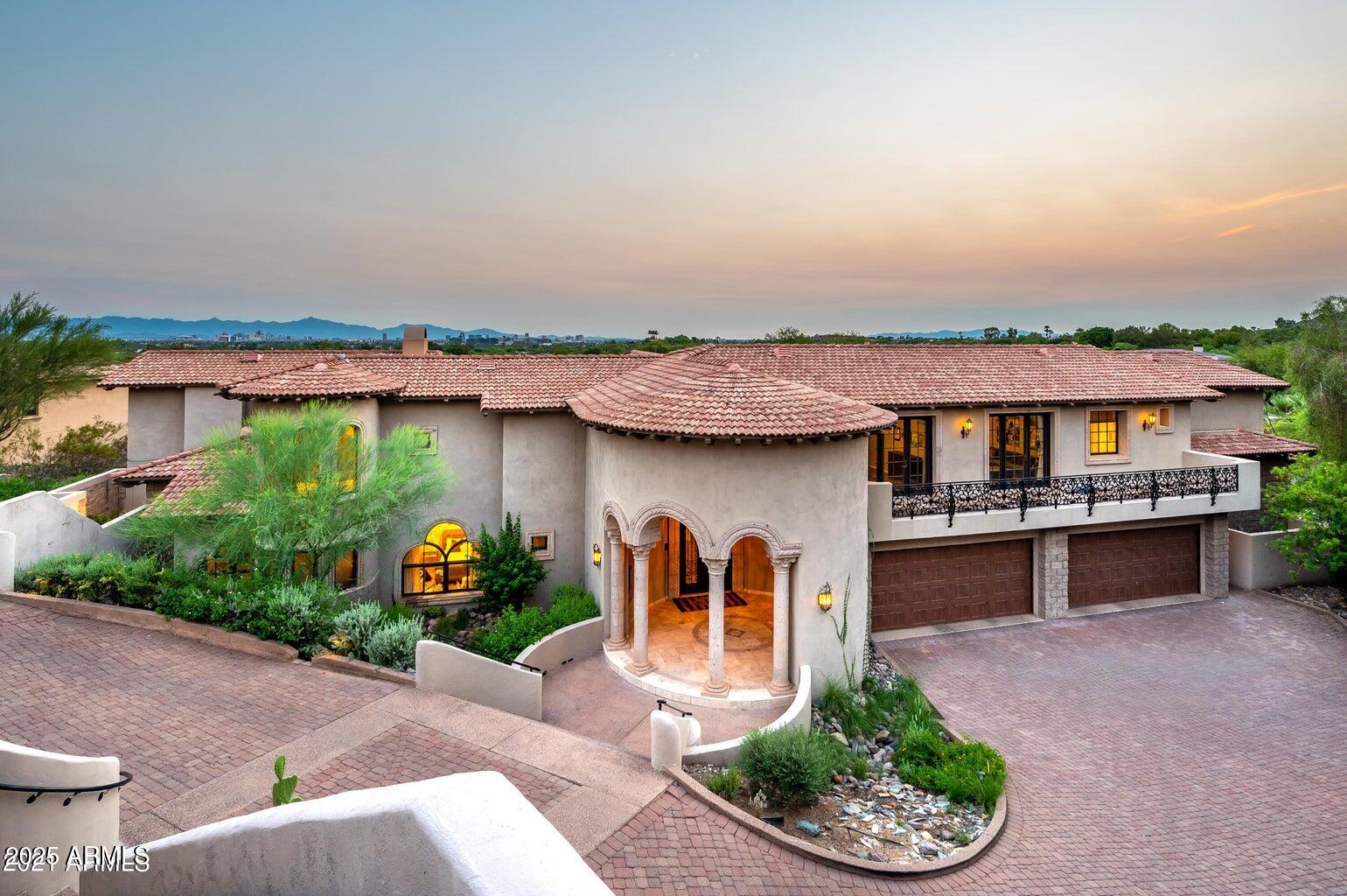 6050 North Paradise View Drive Paradise Valley, AZ 85253 - Photo 7 of 79 a front view of a house with a yard and potted plants