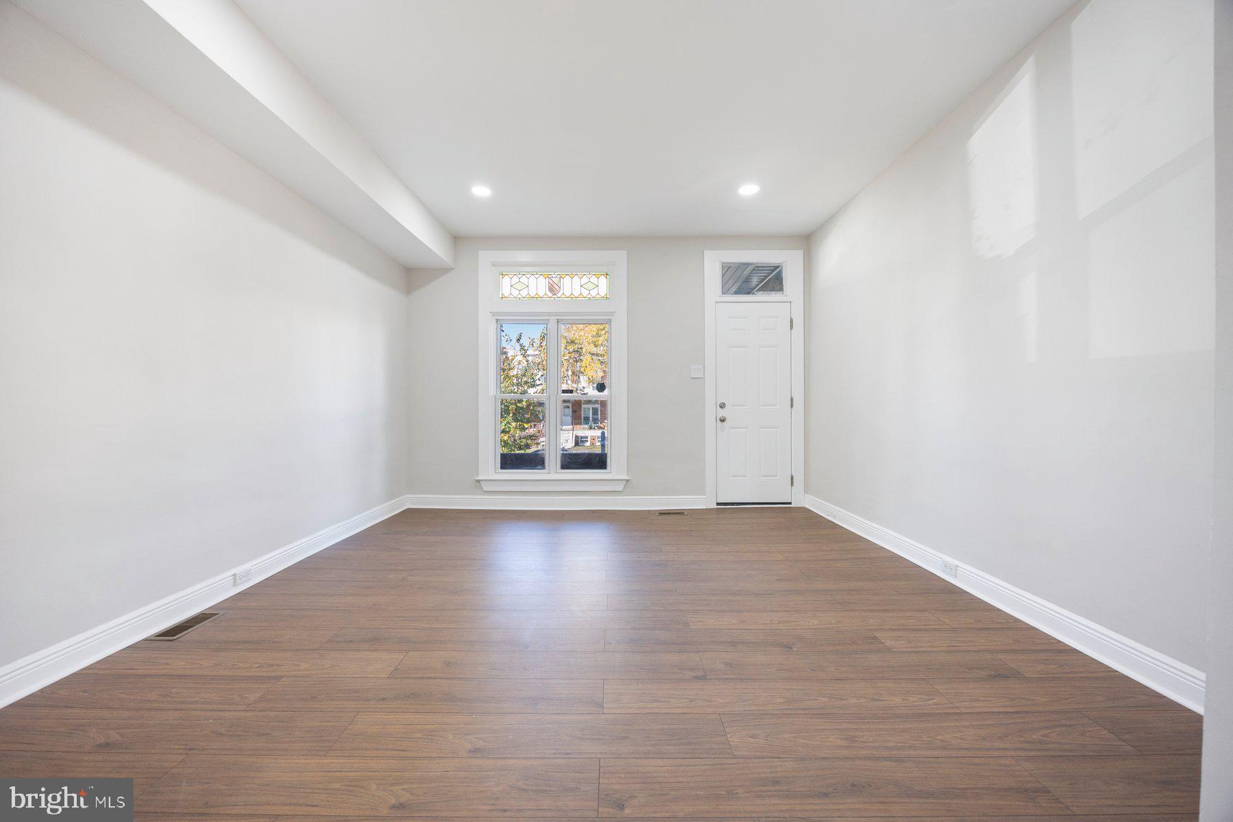 117 Collins Avenue Baltimore, MD 21229 - Photo 3 of 27 wooden floor in an empty room with a window