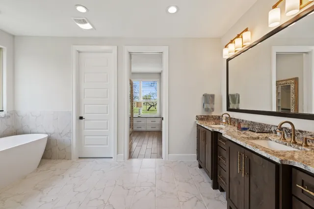 a bathroom with a tub sink and mirror