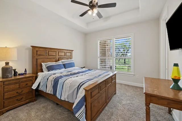 a bedroom with a bed a window and a flat screen television