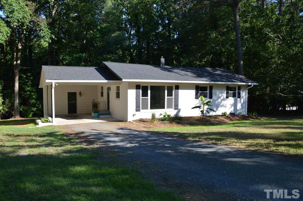 a front view of a house with a garden and porch
