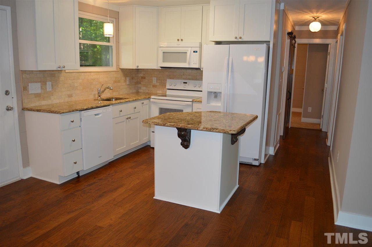 110 Nancy Rhodes Drive Durham, NC 27712 - Photo 11 of 24 a kitchen with stainless steel appliances granite countertop a sink a stove a refrigerator and island with wooden floor