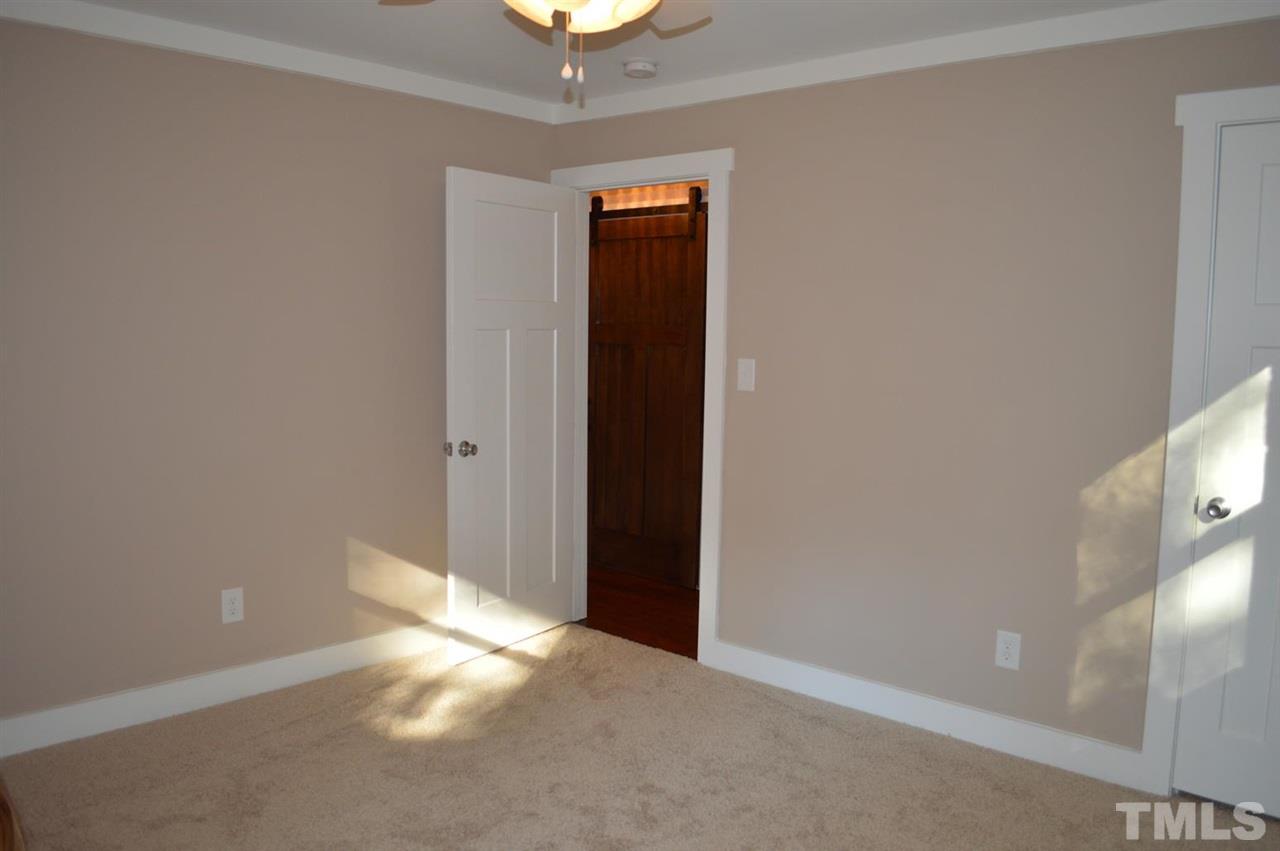 110 Nancy Rhodes Drive Durham, NC 27712 - Photo 15 of 24 an empty room with a chandelier fan and a window