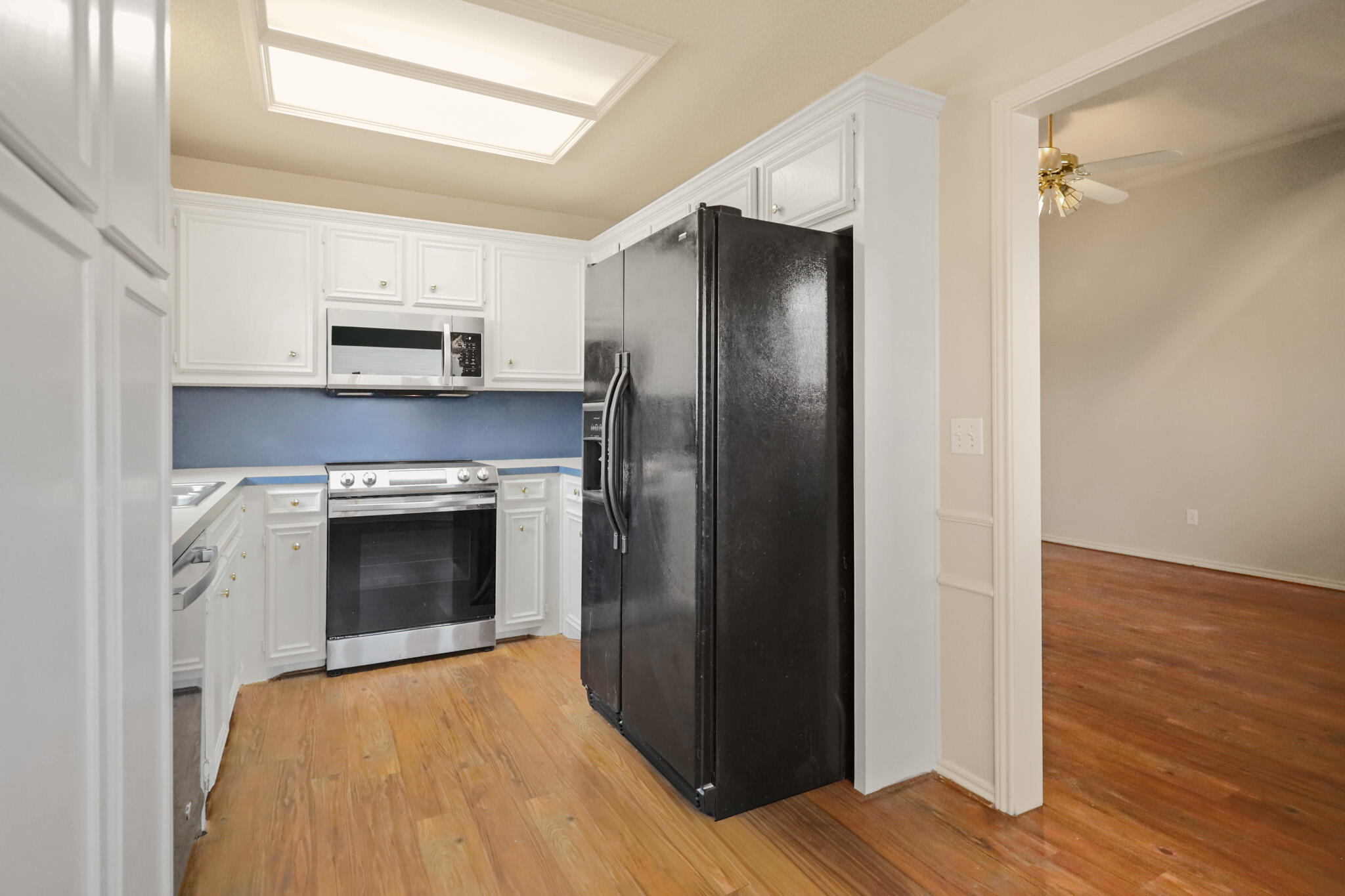 2214 94th Street Lubbock, TX 79423 - Photo 14 of 41 a kitchen with stainless steel appliances a refrigerator stove and wooden floor