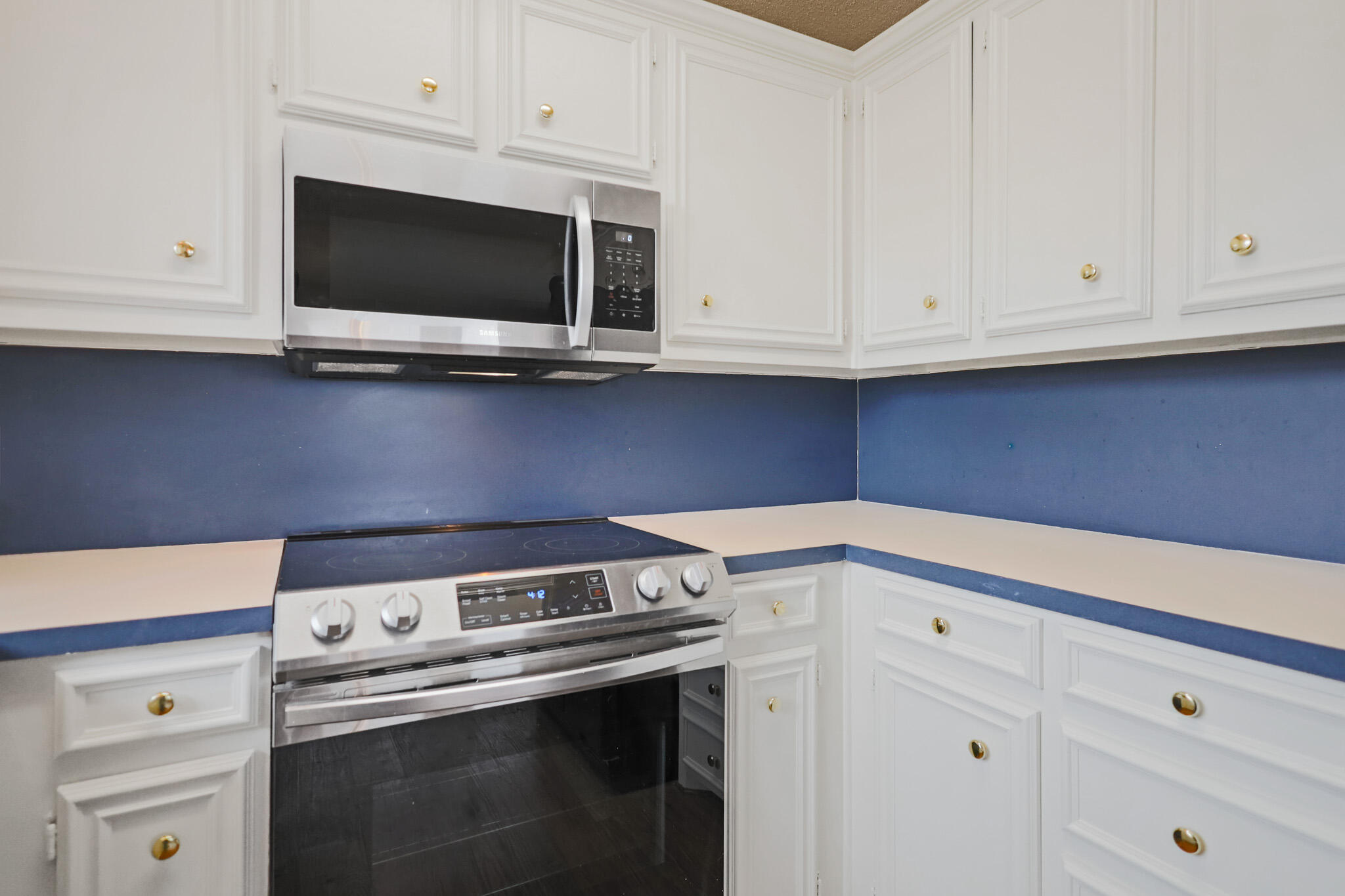 2214 94th Street Lubbock, TX 79423 - Photo 16 of 41 a kitchen with white cabinets and black appliances