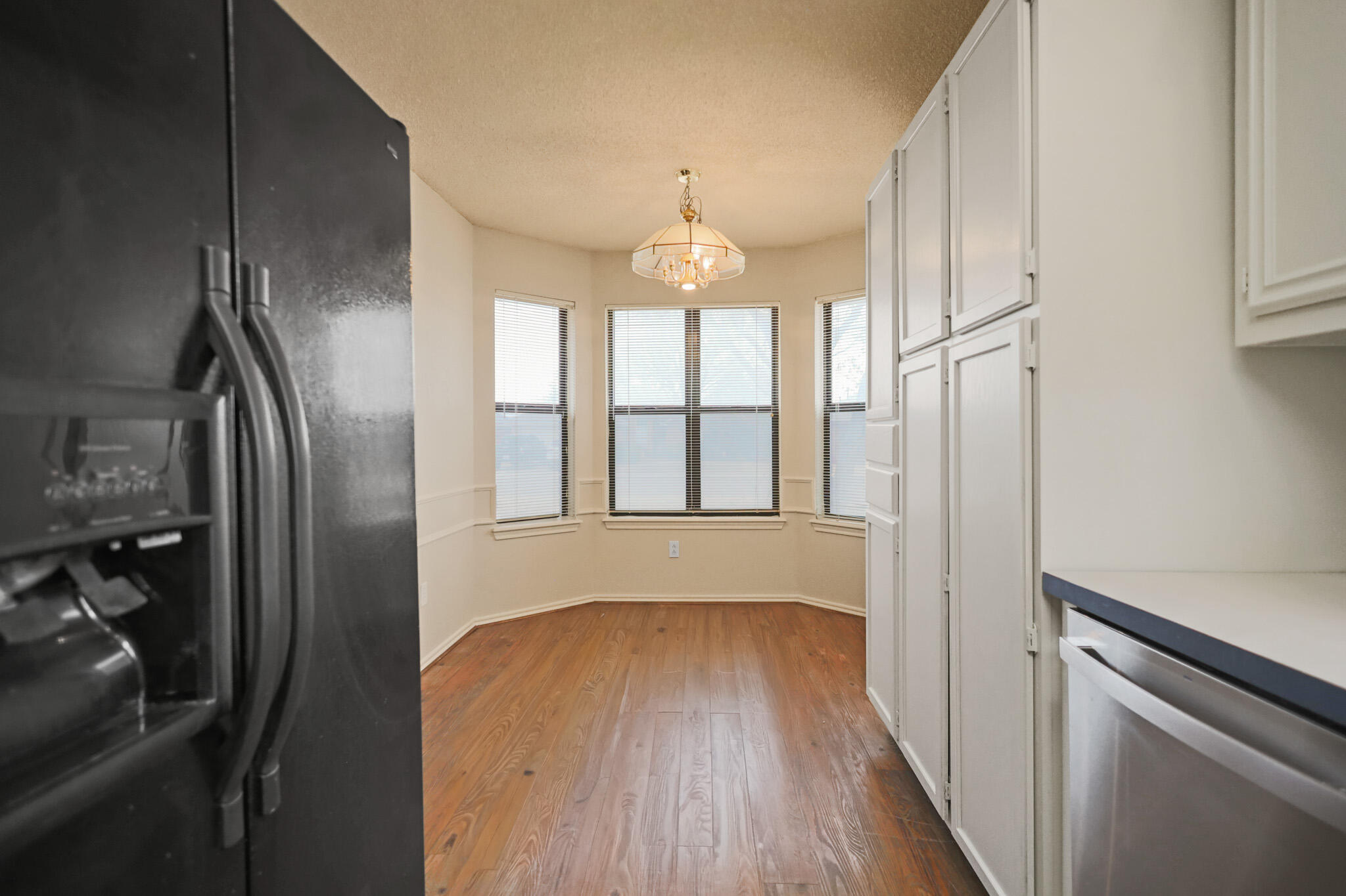 2214 94th Street Lubbock, TX 79423 - Photo 18 of 41 a hallway with wooden floor chandelier and entryway