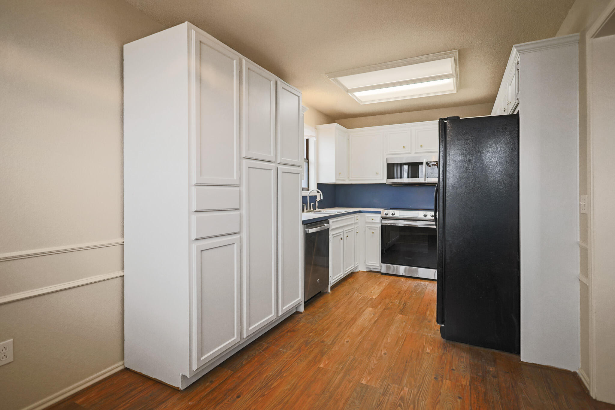 2214 94th Street Lubbock, TX 79423 - Photo 21 of 41 a kitchen with white cabinets and white appliances