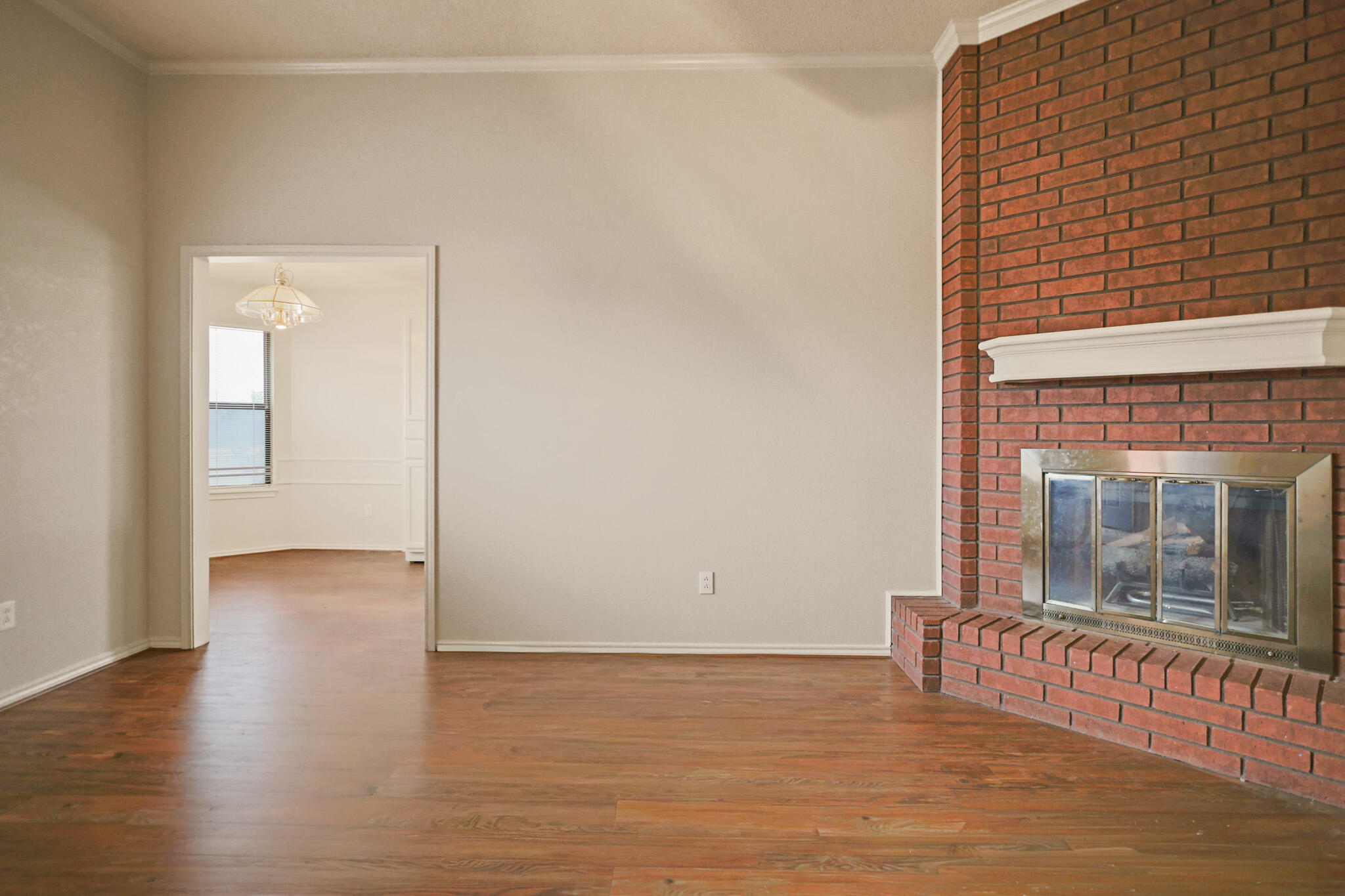 2214 94th Street Lubbock, TX 79423 - Photo 7 of 41 a view of a room with wooden floor and a fireplace