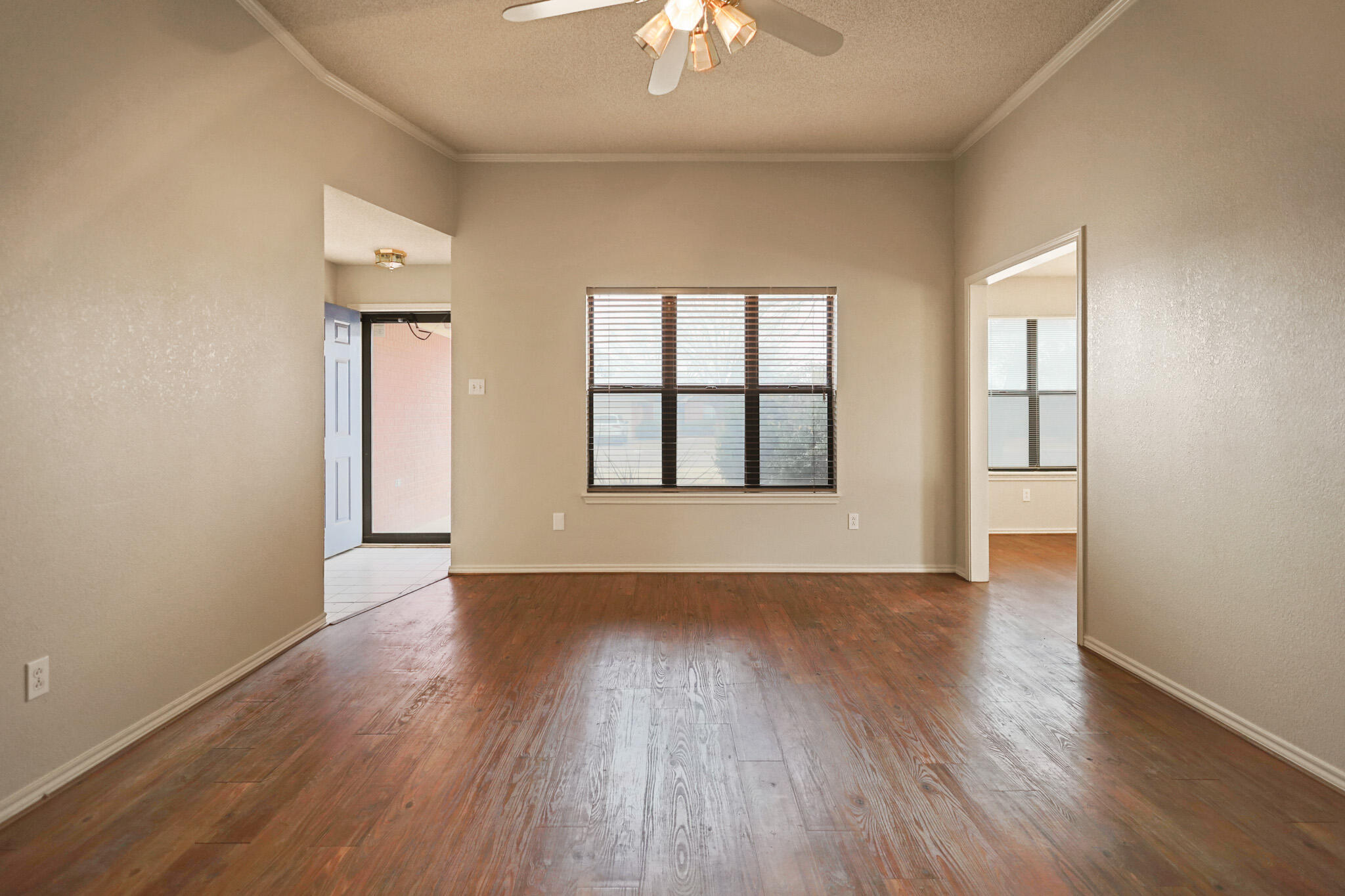2214 94th Street Lubbock, TX 79423 - Photo 9 of 41 an empty room with wooden floor chandelier and windows