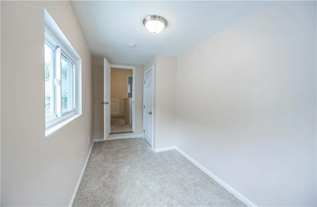 an empty room with windows and closet