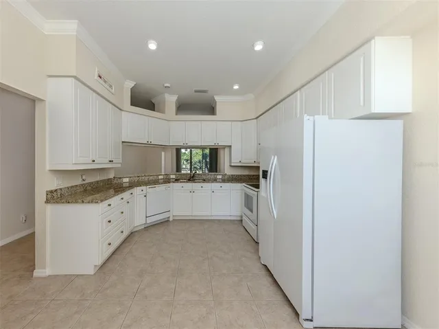 a large white kitchen with stainless steel appliances