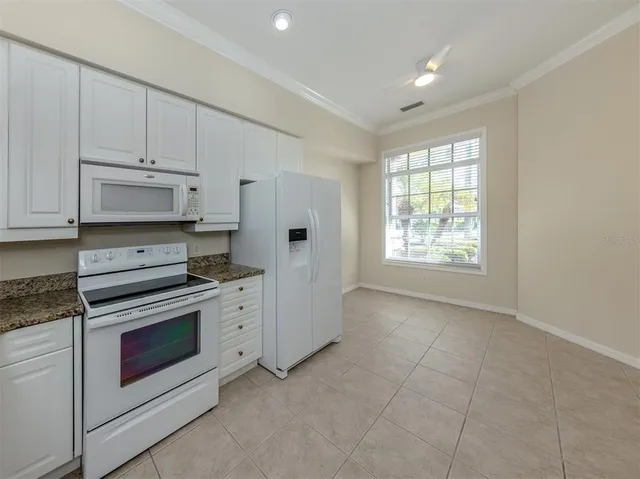a kitchen with cabinets appliances and a window