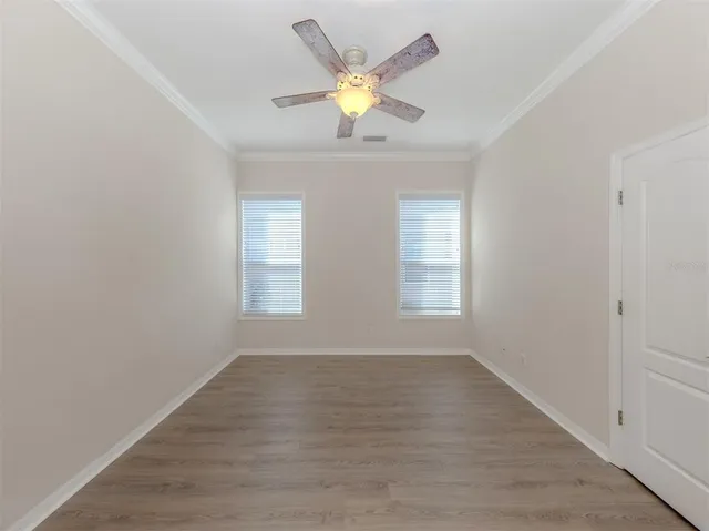 a view of an empty room with window and wooden floor