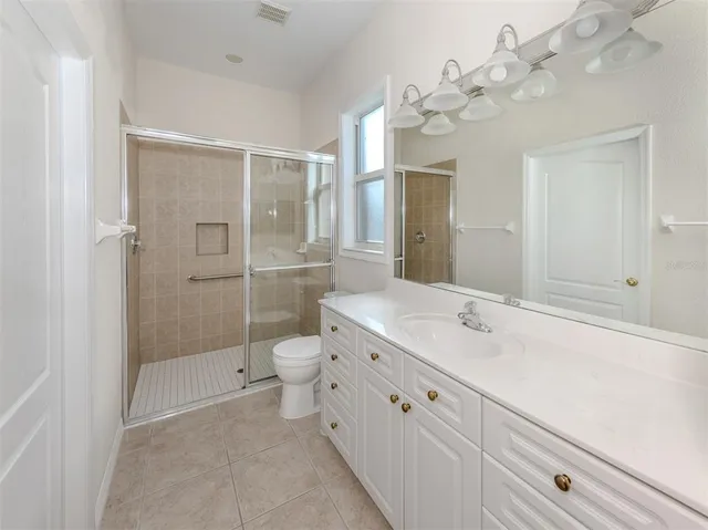 a spacious bathroom with a shower sink and mirror