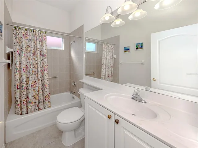 a bathroom with a sink a toilet a mirror a bathtub and shower