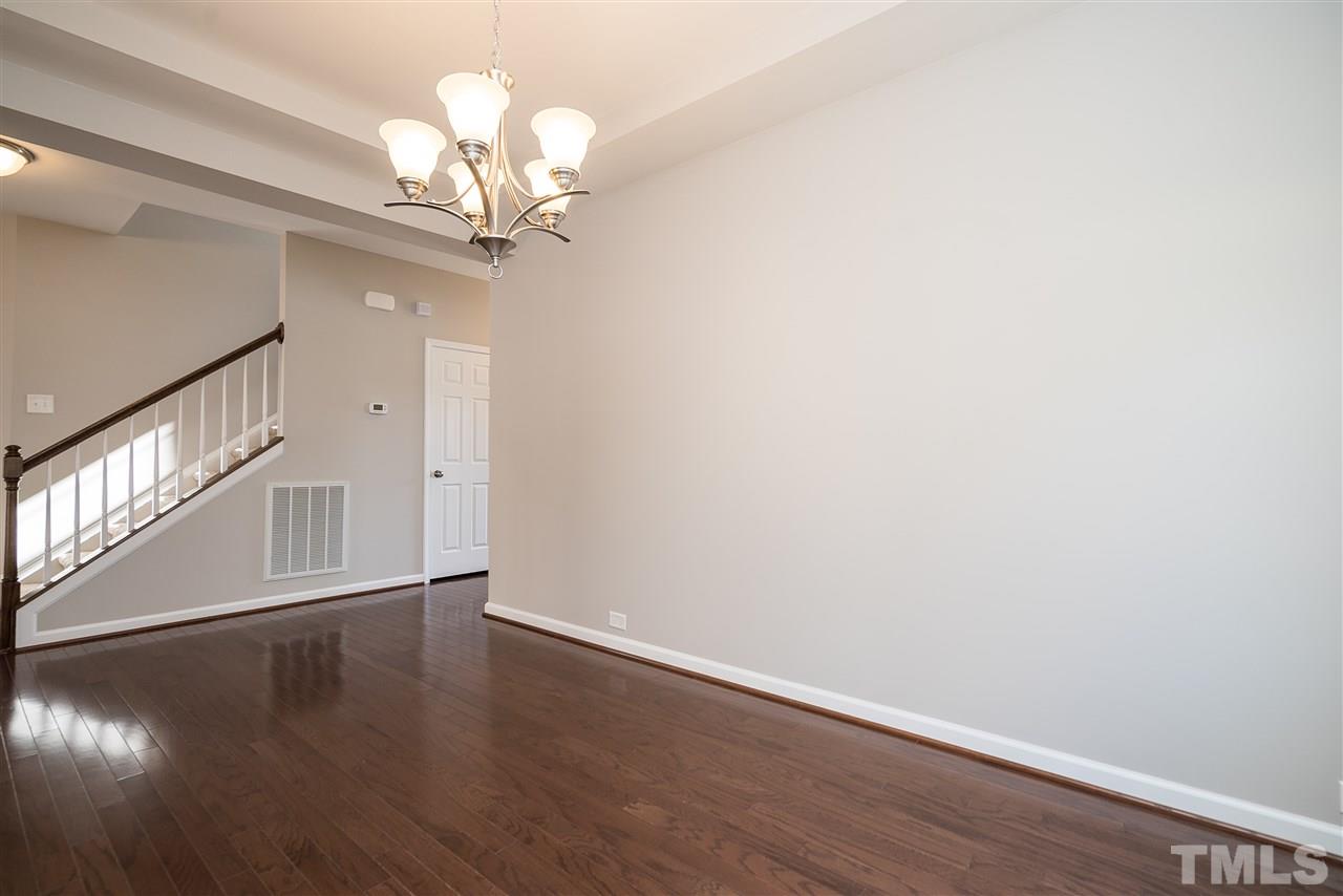 1004 Lakeview Road Durham, NC 27712 - Photo 6 of 25 a view of an empty room with wooden floor and a chandelier