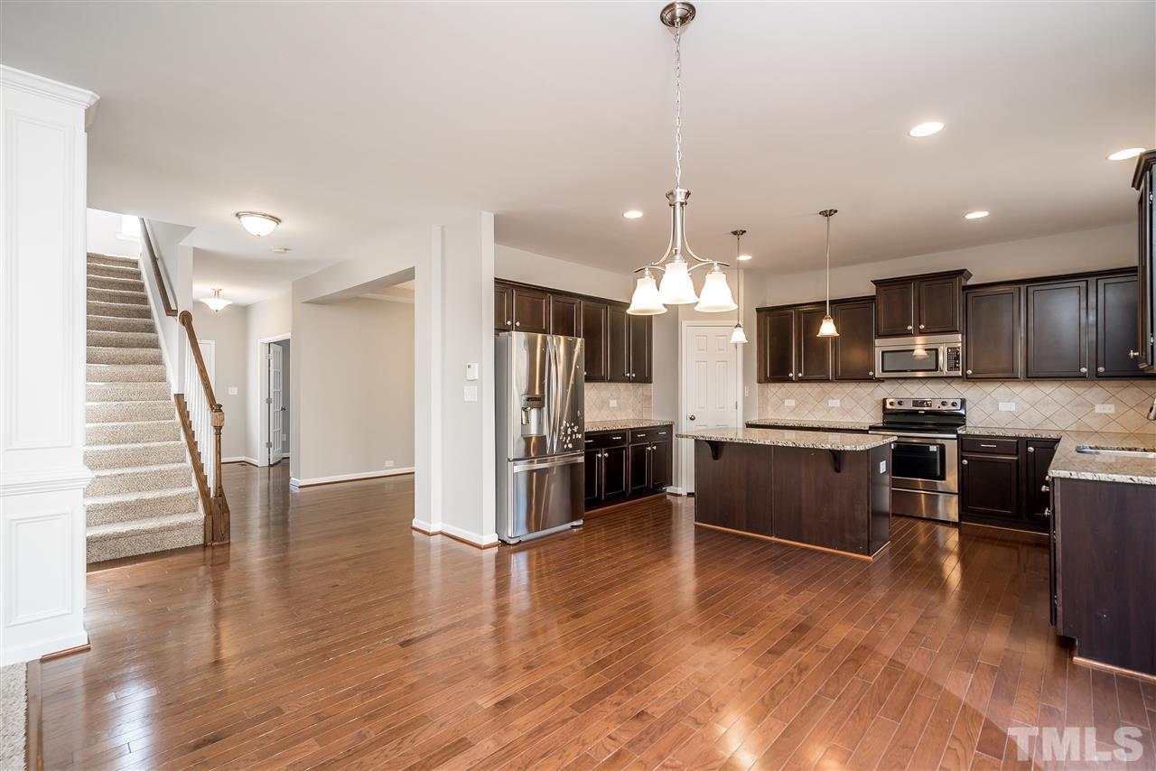 1004 Lakeview Road Durham, NC 27712 - Photo 7 of 25 a large kitchen with a center island wooden floor stainless steel appliances and cabinets