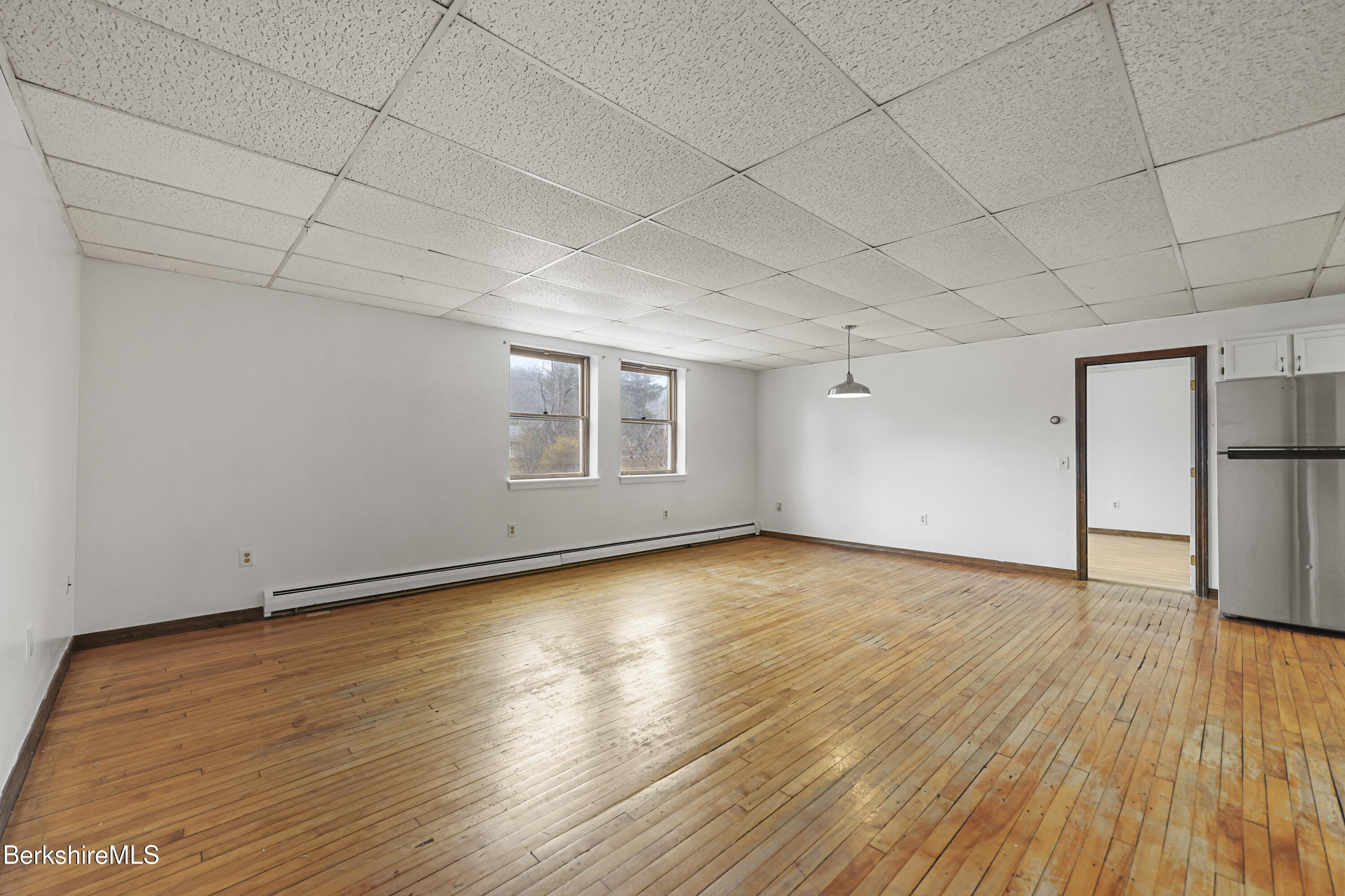 55 Crystal Street, Unit 8 Lenox, MA 01242 - Photo 4 of 12 an empty room with wooden floor and windows