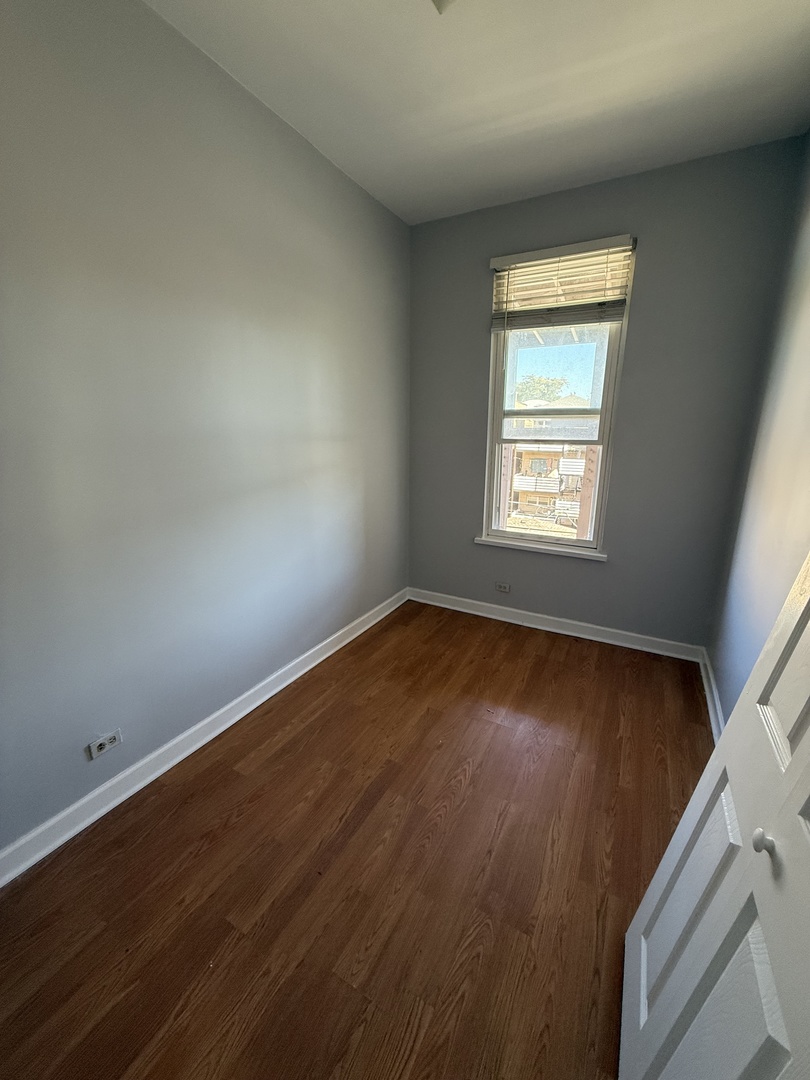 1421 North Rockwell Street, Unit 3R Chicago, IL 60622 - Photo 5 of 8 an empty room with wooden floor and windows