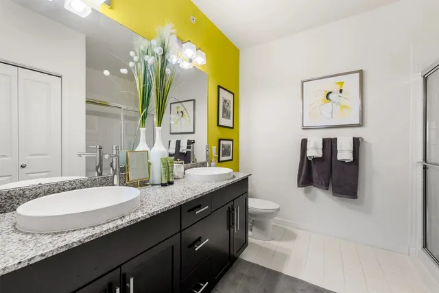 a bathroom with a granite countertop sink a mirror and a toilet