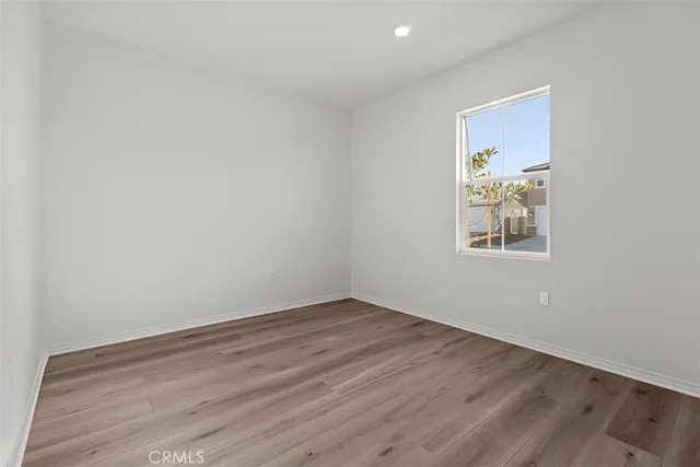 an empty room with wooden floor and wall painting