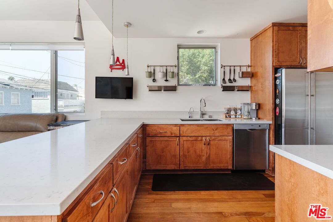 302 South Venice Boulevard Venice, CA 90291 - Photo 12 of 46 a kitchen with stainless steel appliances kitchen island granite countertop a refrigerator and a stove top oven