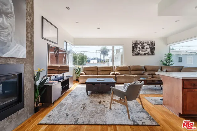 a living room with furniture fireplace and a large window