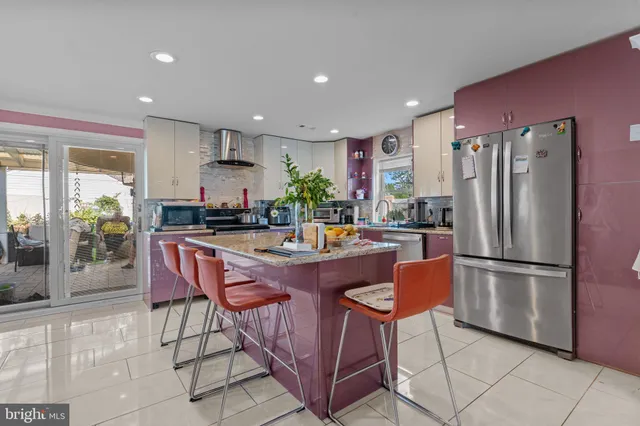 a living room with furniture a rug kitchen view and a large window