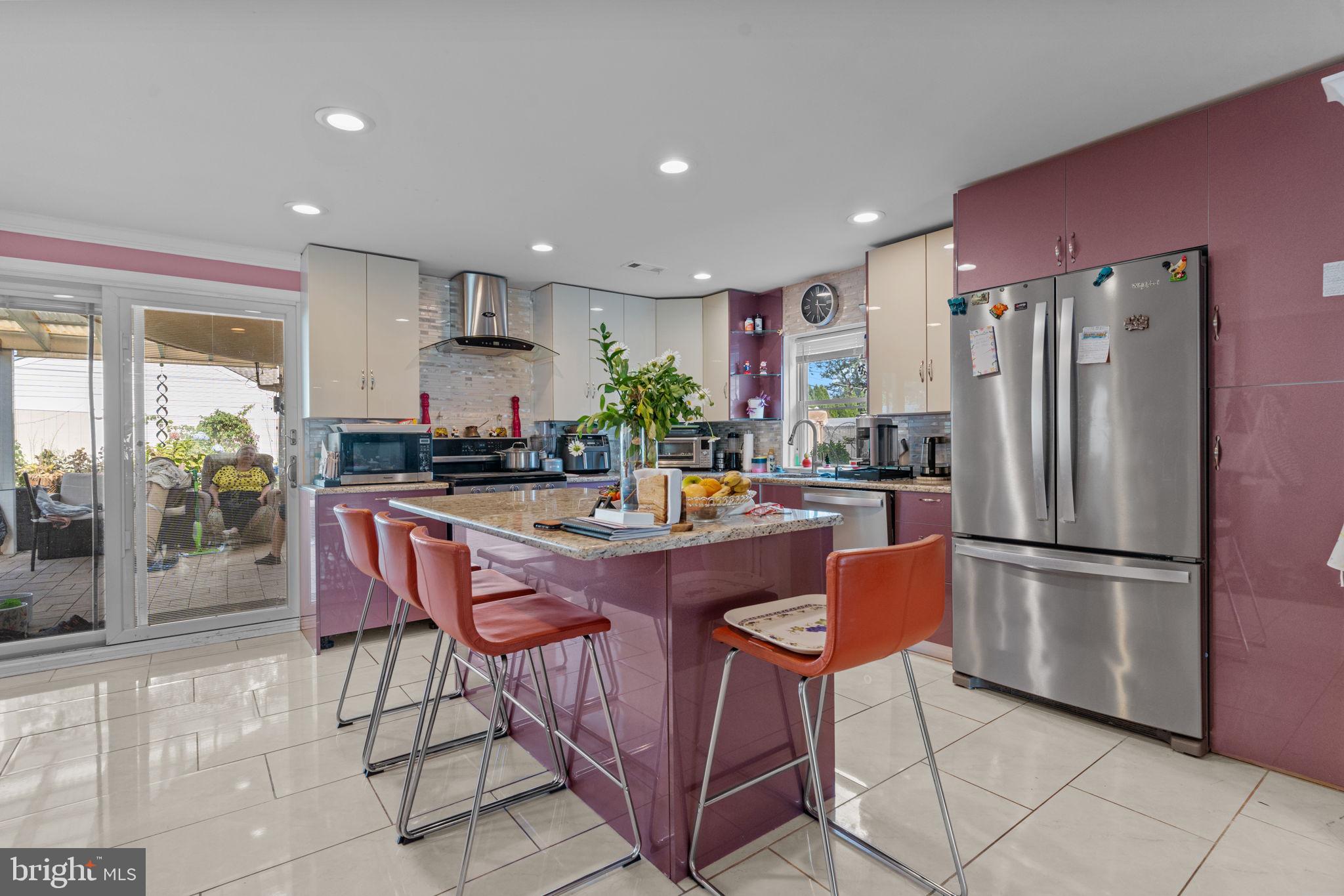 813 Piermont Street Philadelphia, PA 19116 - Photo 23 of 37 a kitchen with stainless steel appliances granite countertop a refrigerator a stove a sink a dining table and chairs with wooden floor