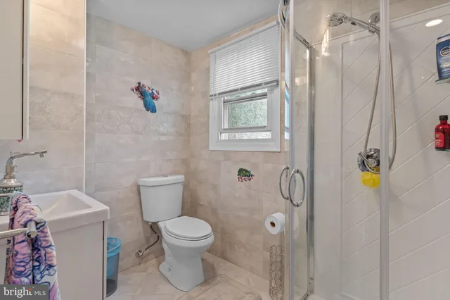 a bedroom with a bed couches chair and a large window