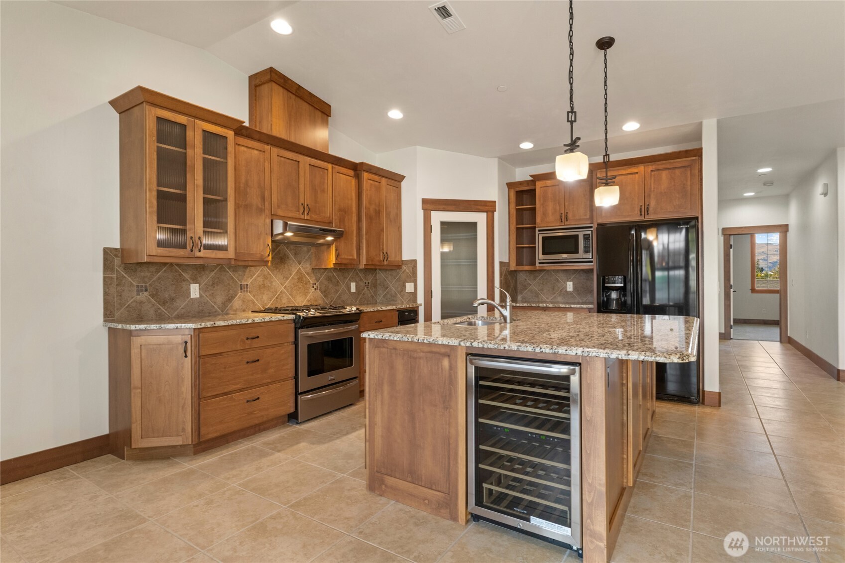 1051 North Baker Avenue, Unit B203 East Wenatchee, WA 98802 - Photo 13 of 33 a kitchen with kitchen island granite countertop a stove top oven a sink a refrigerator and a island