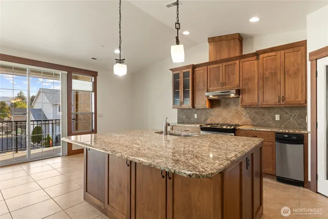 a kitchen with granite countertop a stove and a sink