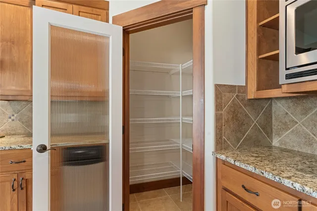 a kitchen with kitchen island a counter top a stove a sink and a large window