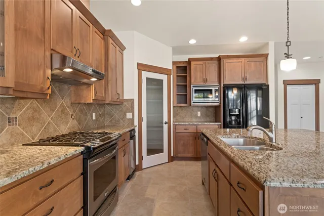 a kitchen with stainless steel appliances granite countertop a stove and cabinets
