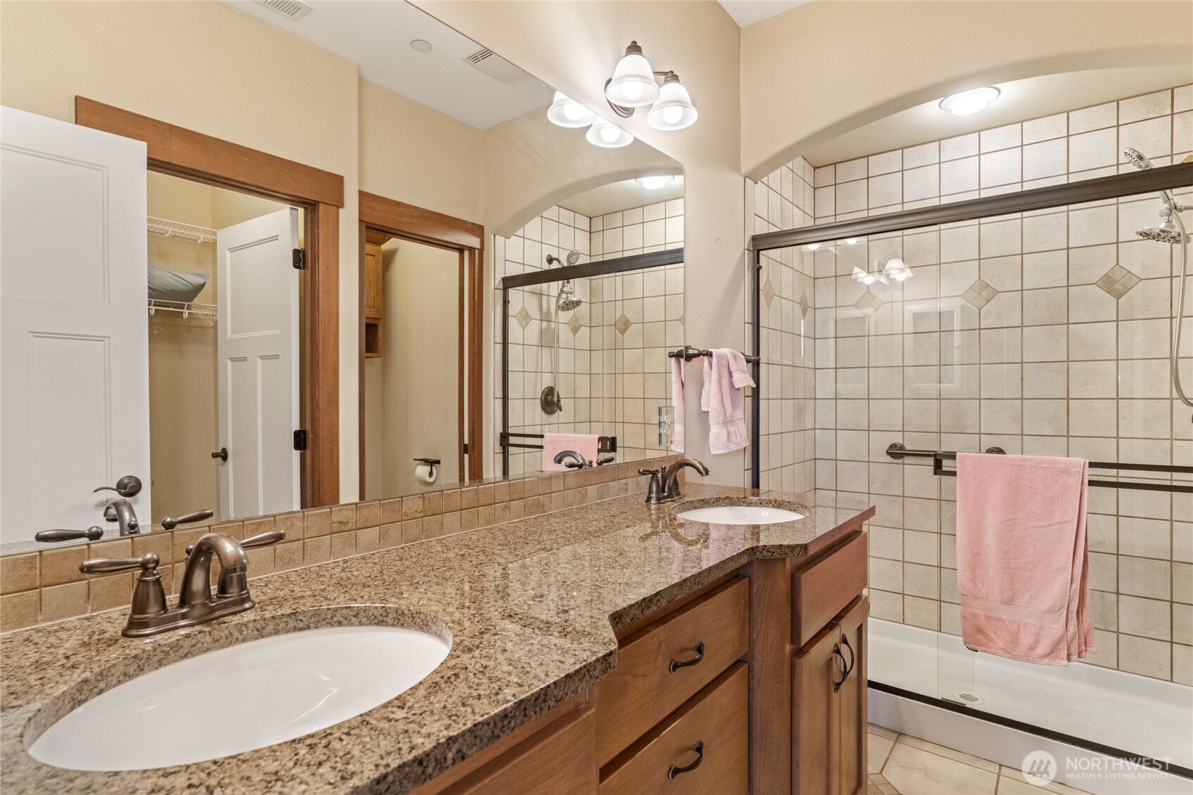 1051 North Baker Avenue, Unit B203 East Wenatchee, WA 98802 - Photo 30 of 33 a bathroom with a granite countertop double vanity sink a mirror and a shower