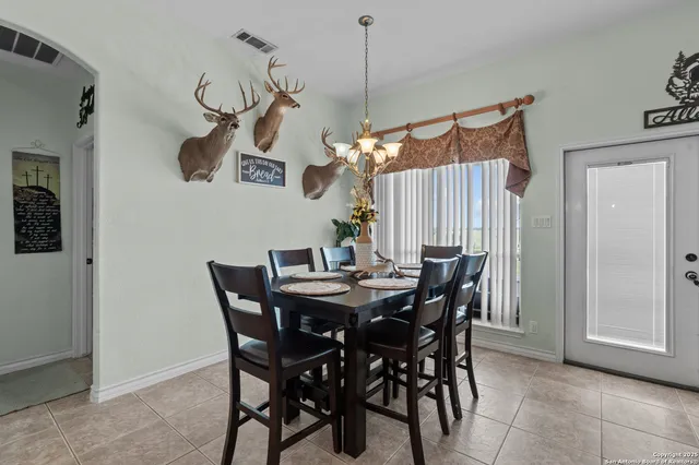 a view of a dining room with furniture and chandelier