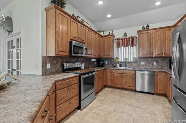 a kitchen with stainless steel appliances granite countertop a refrigerator sink and cabinets