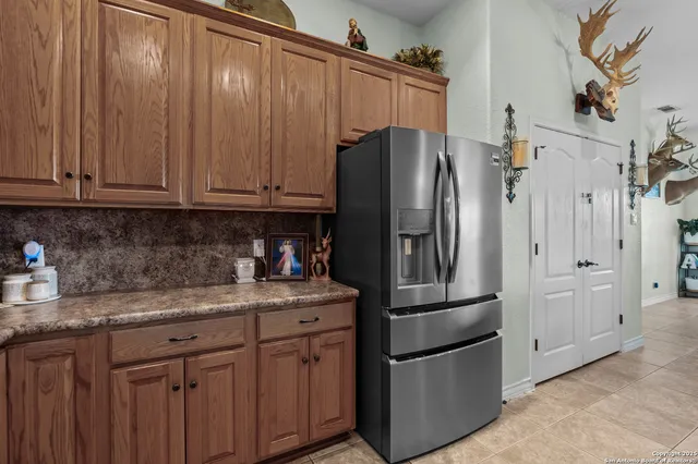 a kitchen with stainless steel appliances granite countertop a refrigerator a stove and a sink with cabinets