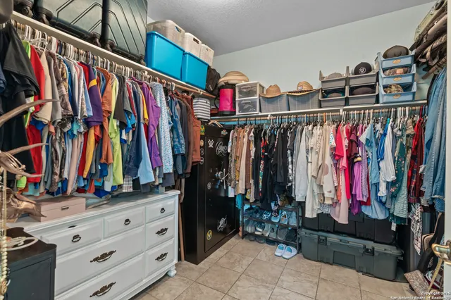 a view of walk in closet with clothes