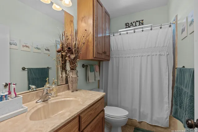 a bathroom with sink a mirror a toilet and vanity