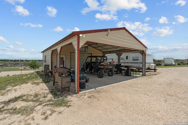 a view of a house with wooden roof and sitting area