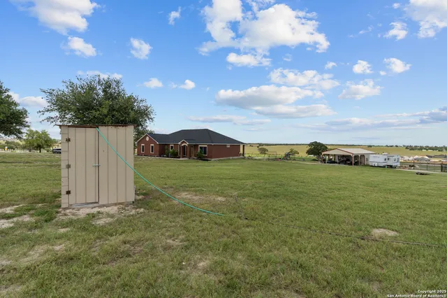 a view of a field with an tree and a yard