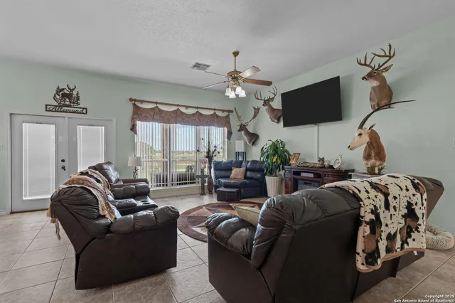 a living room with furniture a flat screen tv and a large window