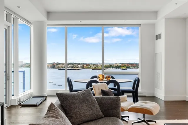 a living room with furniture a rug and a floor to ceiling window