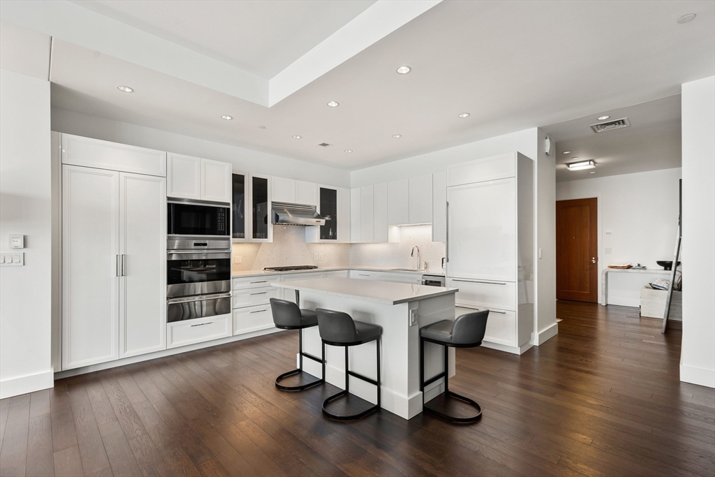 22 Liberty Drive, Unit 10D Boston, MA 02210 - Photo 11 of 26 a view of a kitchen with kitchen island stainless steel appliances refrigerator stove microwave and cabinets