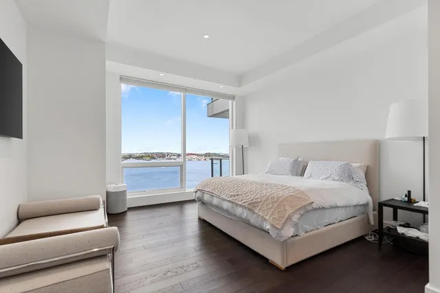 a spacious bedroom with a bed and a flat screen tv