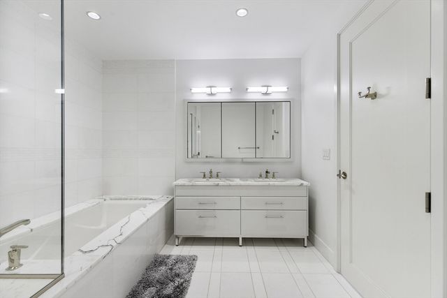 a bathroom with a granite countertop bathtub shower sink and mirror